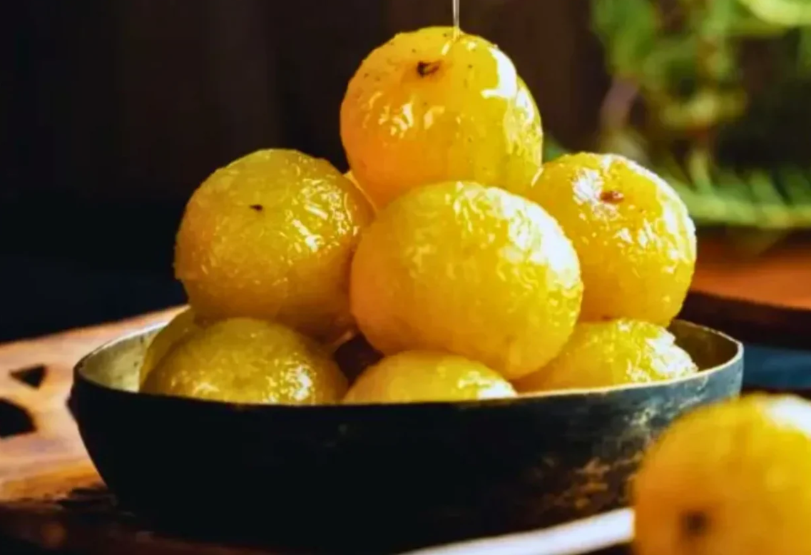 Sweet amla murraba with whole Indian gooseberries in sugar syrup in decorative glass jar
